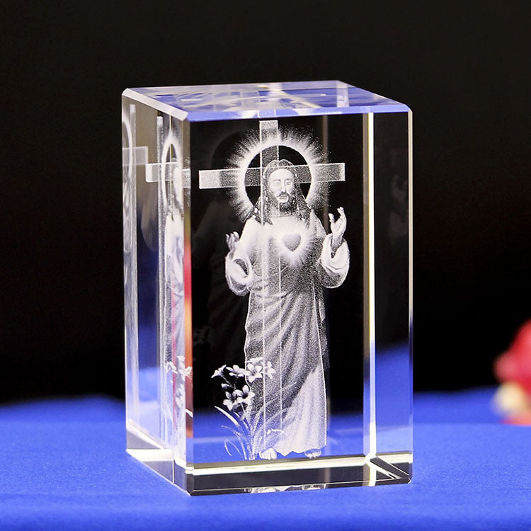 Crystal block with engraved image of a religious figure on a dark background