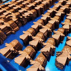 Wooden figurines of a religious figure on a blue surface