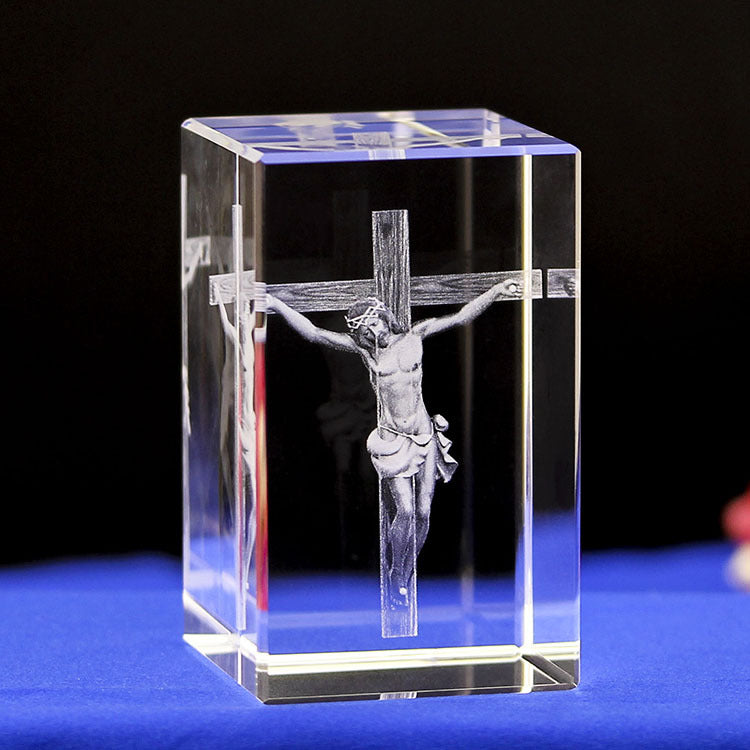 Crystal block with 3D laser engraving of a crucifixion scene on a blue surface.