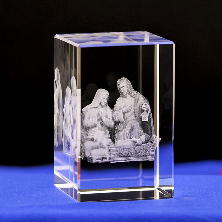 Crystal block with 3D engraved nativity scene on a blue surface