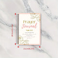 Prayer journal with floral design and measurements on a marble background
