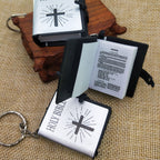Miniature Holy Bible keychain with cross design on a textured surface
