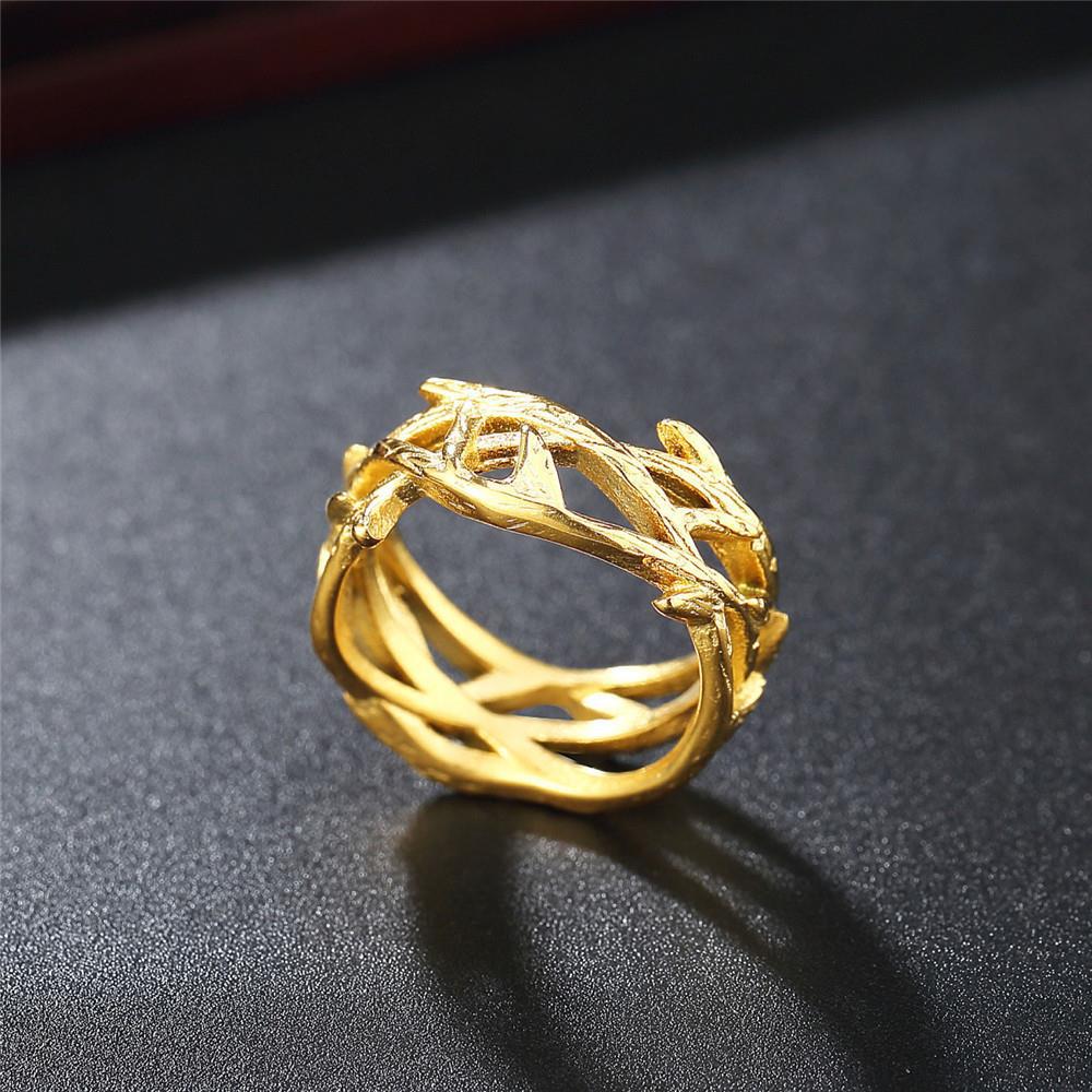 Gold ring with intricate design on a dark surface