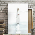 Man in a white robe standing in water with a stone wall and books in the background