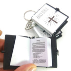 Miniature book-shaped keychain with Bible text on a white background